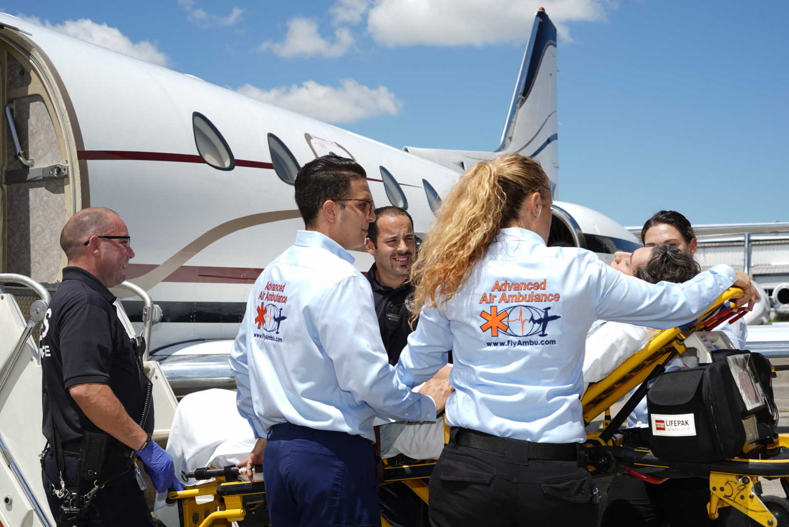 Patient and nurses help load the patient onto the aircraft.